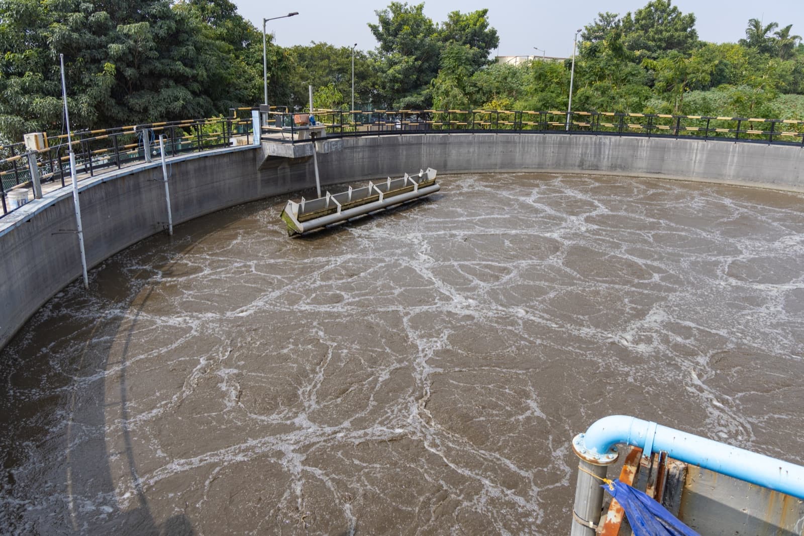 Aeration tanks at a sewage treatment plant with clean industrial walkways and active water treatment infrastructure.